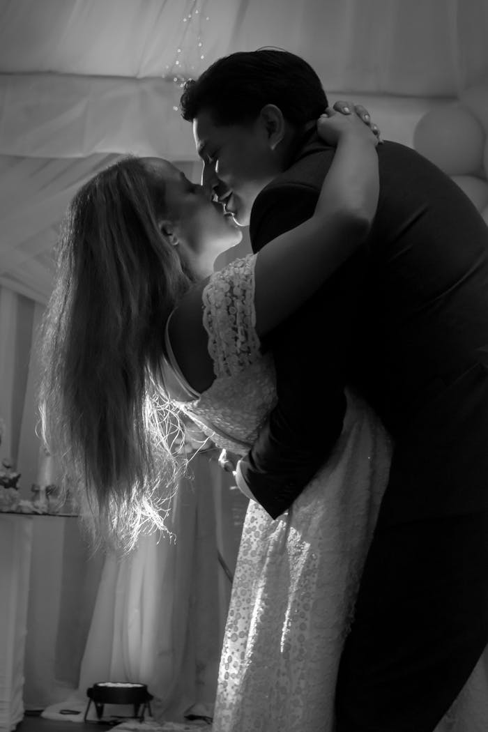 A couple shares a romantic dance at their wedding, captured in elegant black and white.