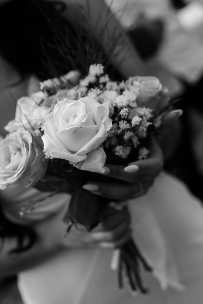 Elegant black and white close-up of a bridal bouquet with roses, perfect for wedding themes.